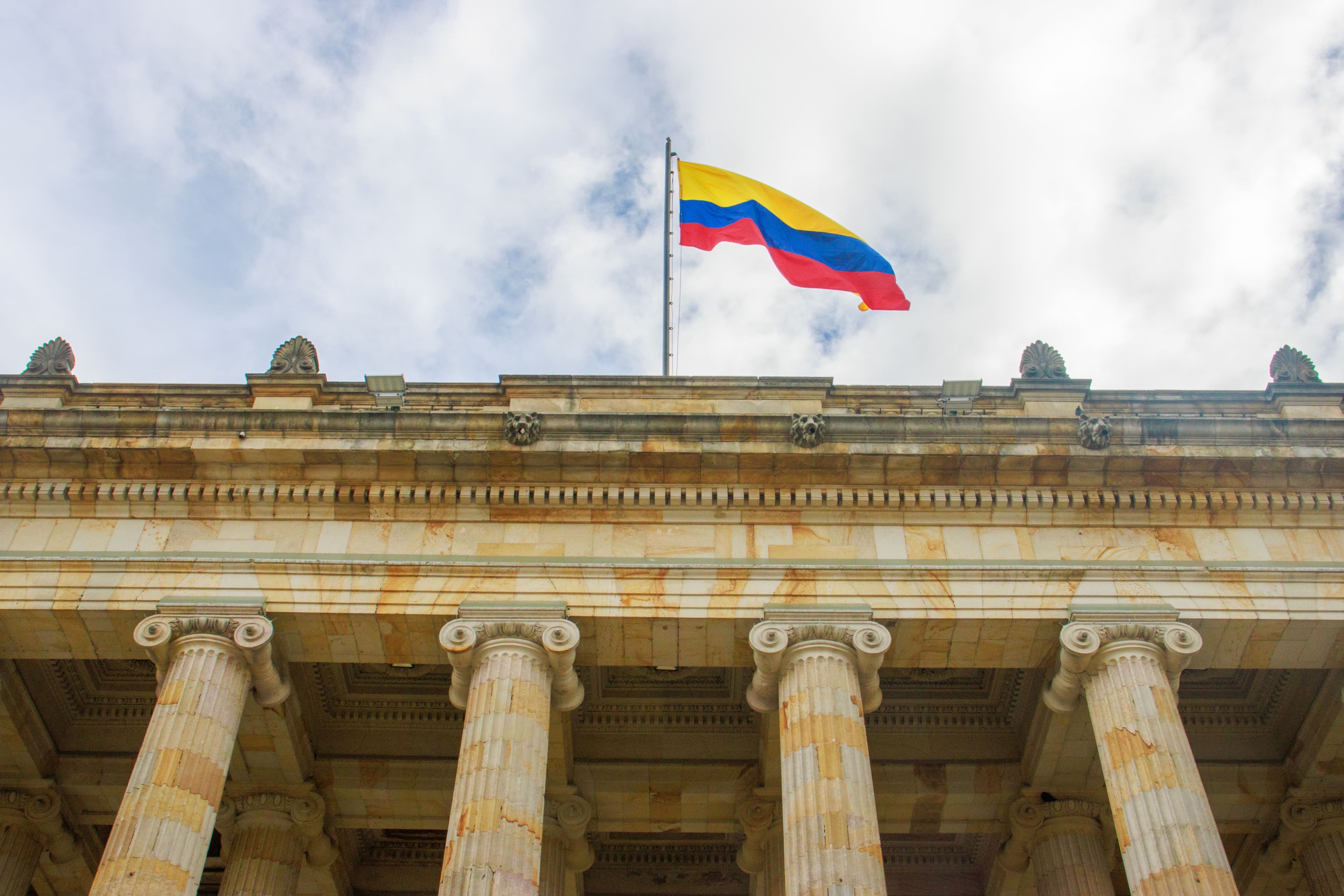 Colombian flag over greek style columns of a municipal building